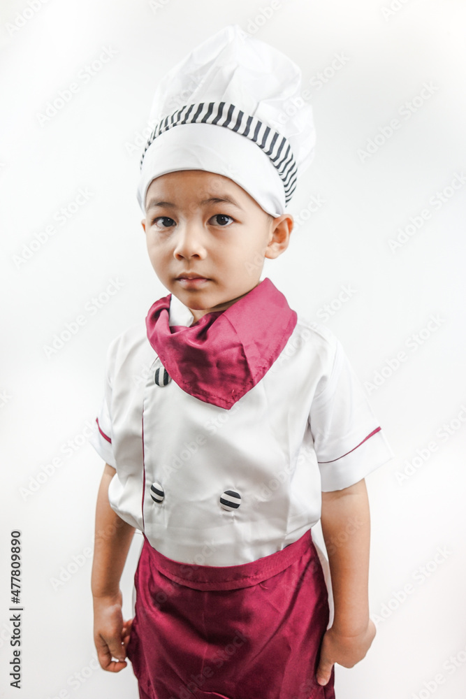 Young Asian man dressed as a chef preparing to cook. Portrait of a happy cute male child cook pointing on copy space, isolated on white background. Food and cooking concept.
Young Asian man dressed as a chef preparing to cook. Portrait of a happy cute male child cook pointing on copy space, isolated on white background. Food and cooking concept.