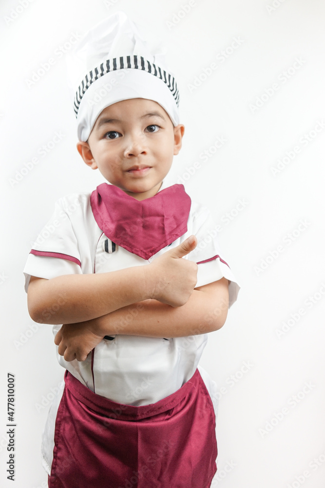 Young Asian man dressed as a chef preparing to cook. Portrait of a happy cute male child cook pointing on copy space, isolated on white background. Food and cooking concept.
Young Asian man dressed as a chef preparing to cook. Portrait of a happy cute male child cook pointing on copy space, isolated on white background. Food and cooking concept.