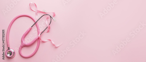 Vászonkép Pink ribbon and stethoscope on color background with space for text