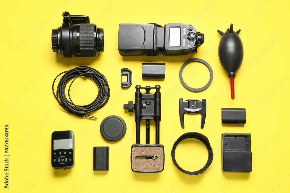 Flat lay of equipment for professional photographer on yellow background