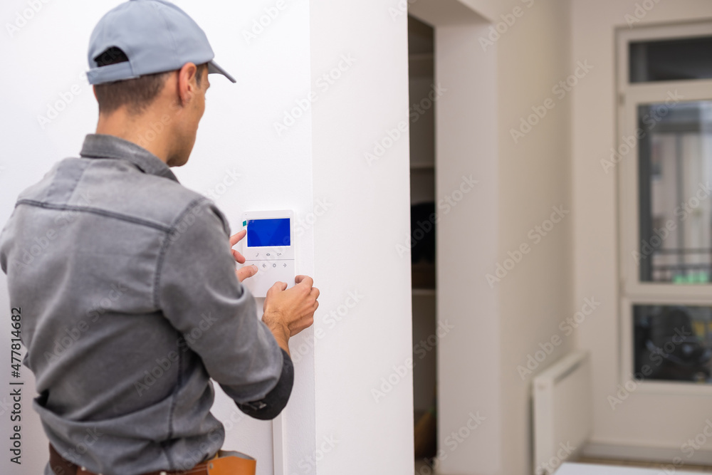 handsome young electrician repairing intercom handsome young electrician repairing intercom