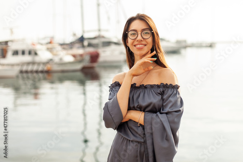Portrait of a cute beautiful woman with glasses on the beach in early morning © splitov27