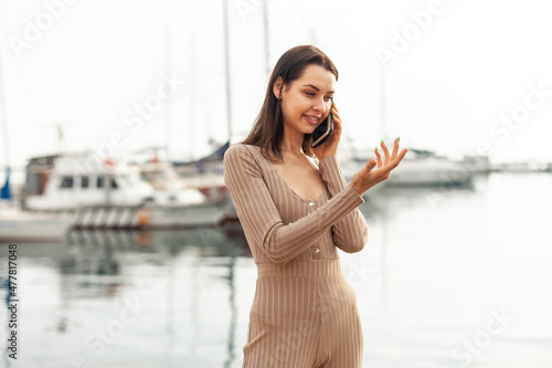 Smiling beautiful woman talking on phone in the yacht club early morning © splitov27