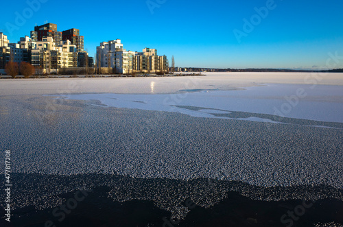 Winter day in Scandinavia, Frost covered ice of frozen lake Malaren, view of Lillaudden residential area on lake front, Vasteras, Sweden