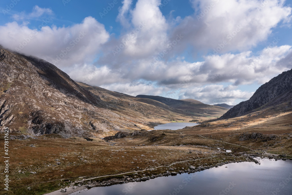 Aerial view of flying drone Epic Autumn Fall landscape image of view along Ogwen vslley in Snowdonia National Park with moody sky and mountains