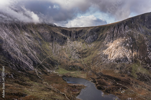 Aerial view of flying drone Epic dramatic Autumn landscape image of Llyn Idwal in Devil's Kitchen in Snowdonia National Park with gorgeous light