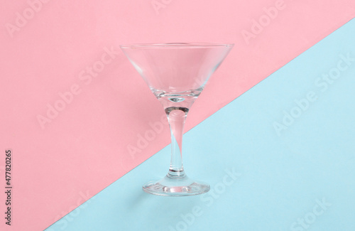 Cocktail empty glass on a blue-pink pastel background. Minimalism. Top view