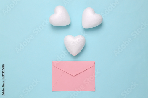 Love letter. Envelope with white hearts on blue pastel background © splitov27