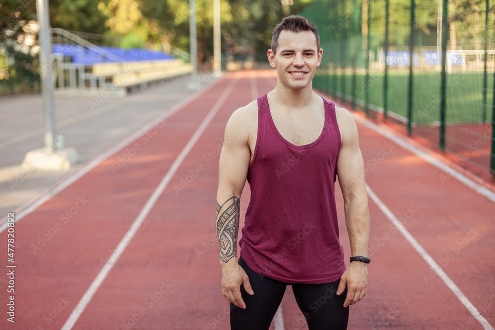 Portrait of a young handsome athletic male at the stadium. Smiling sport man Portrait of a young handsome athletic male at the stadium. Smiling sport man