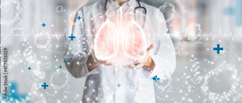 Canvas Print Doctor holding hologram of human lungs surrounded by oxygen as a concept of respiratory health
