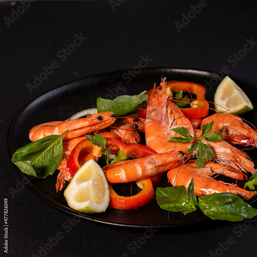 A plate with king prawns served with fresh lemon and parsley leaves