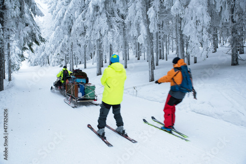 Skiers and snowmobile in winter nature
