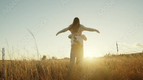 Giovane coppia di ragazza e ragazzo che ballano allegramente in campagna al tramonto photo
