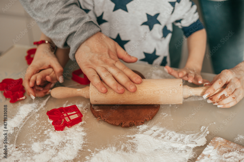 Dad and child together with hands using rolling pin roll out dough on table at home, cozy kitchen, happy hours together, teamwork. Joint hobby. Happy family.
