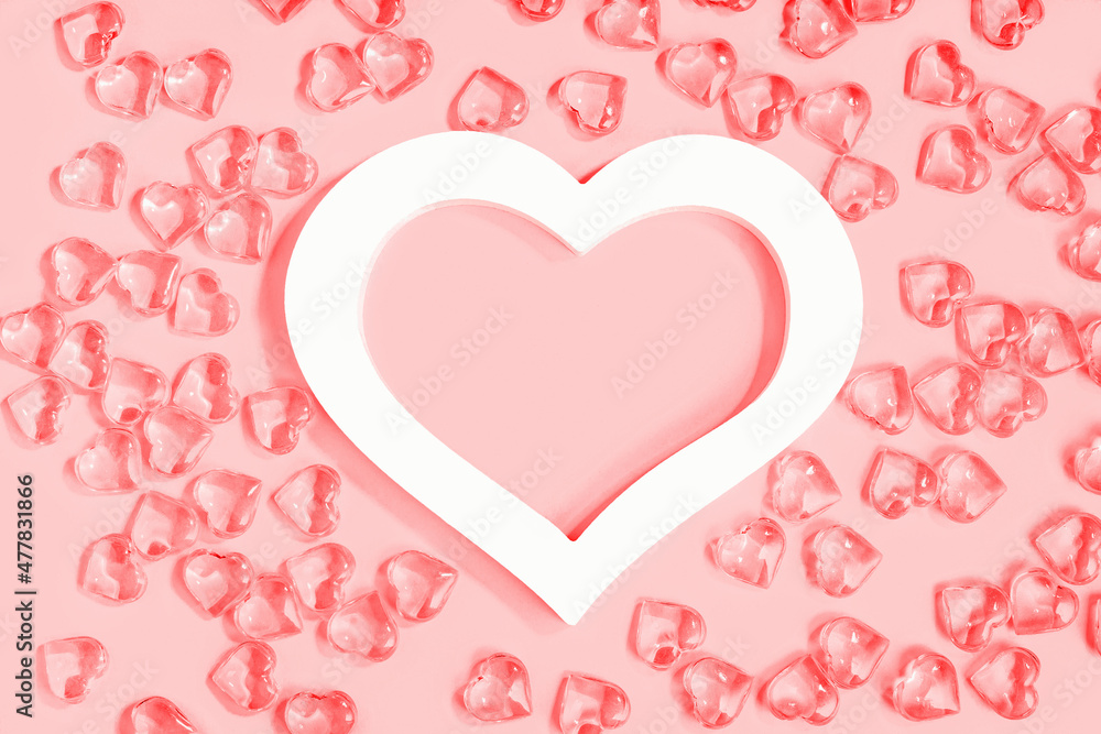 St Valentines day pink background banner. Many glass hearts around white heart frame flat lay. Love or wedding concept