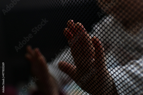 Close up of baby hands touching safety net