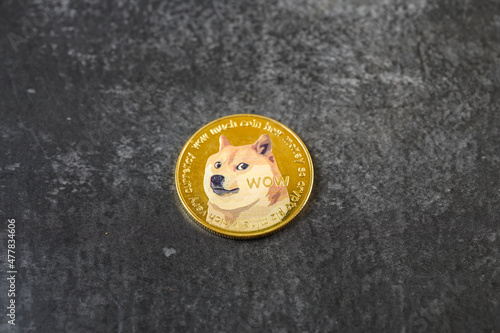Dogecoin cryptocurrency - photo of Dogecoin crypto currency physical gold coin. Symbol of the doge meme coin
