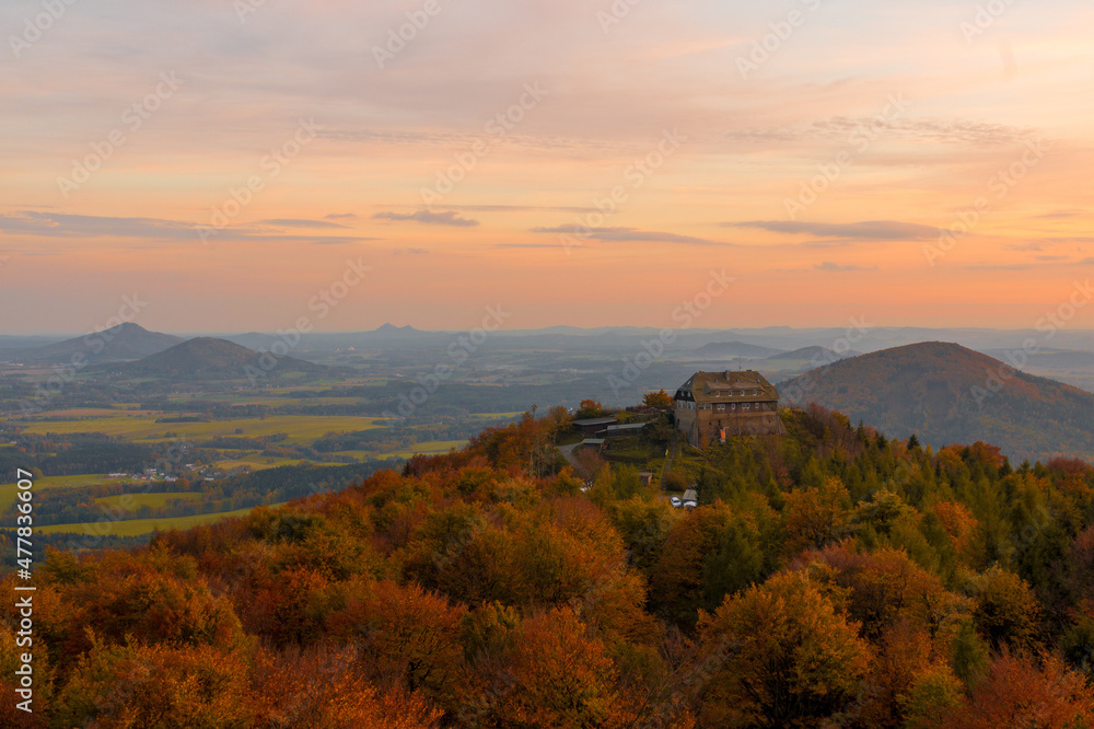 Sonnenuntergang im Herbst auf dem Hochwald im Zittauer Gebirge mit Haus und Laub und Bäumen