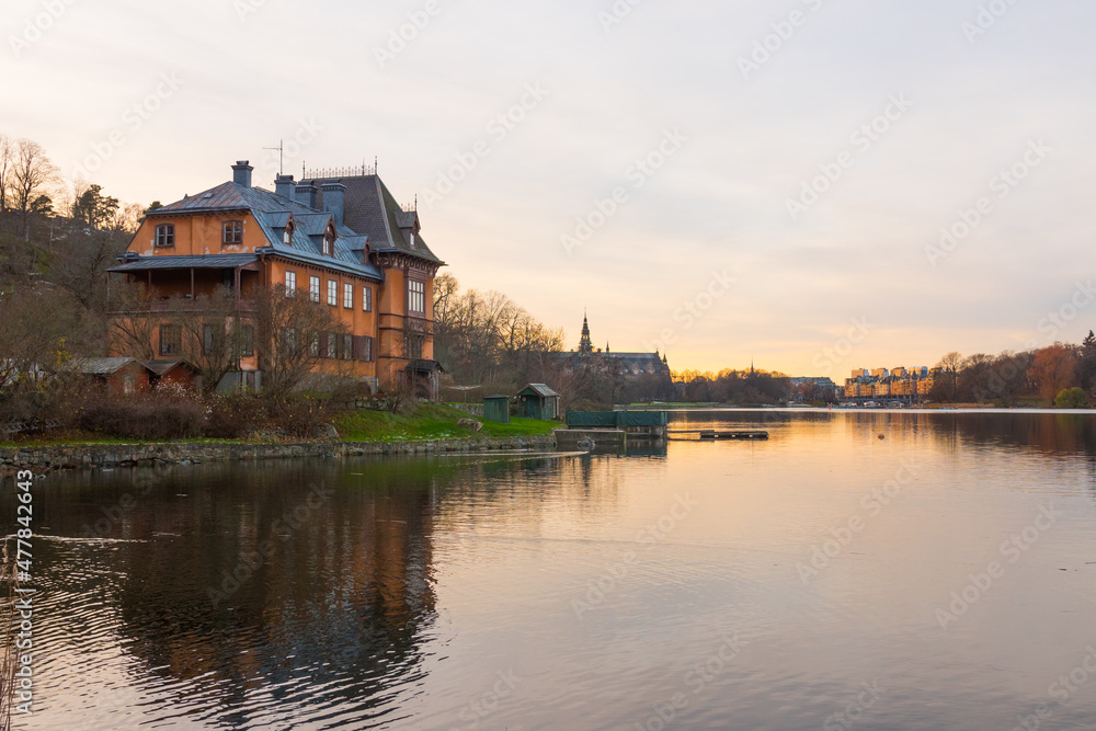 Stockholm, Sweden. Mansion Reflected On Calm Water On The Island Of Djurgarden. Wide Shot