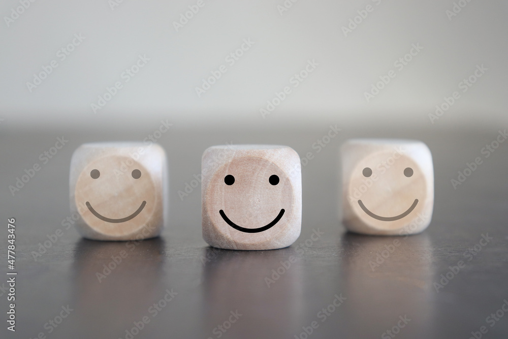 image of wooden blocks with smiling faces icons over table ,building a strong team, human resources and management concept. image of wooden blocks with smiling faces icons over table ,building a strong team, human resources and management concept.