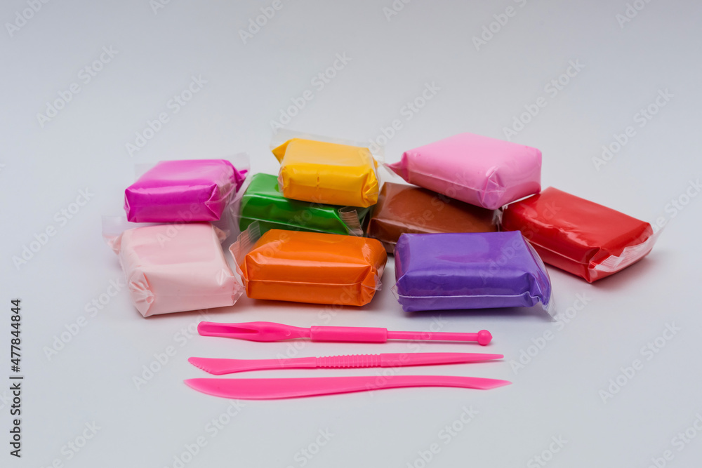 Packages of different colorful plasticine on white background. Packages of different colorful plasticine on white background.