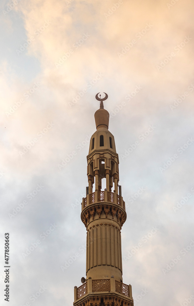 Shot of a minaret with cloudy sky on background. Religion