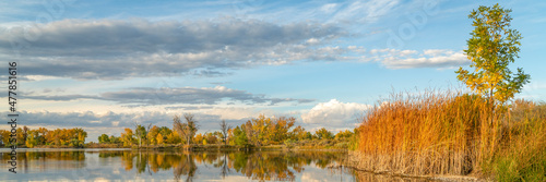 calm lake at sunset in one of Fort Collins natural areas in northern Colorado, fall scenery, panoramic web banner
