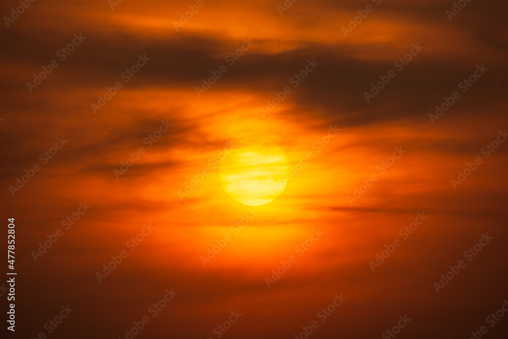 Orange sky and sun shining behind clouds nature background Orange sky and sun shining behind clouds nature background