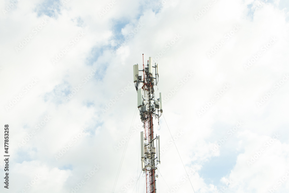 Communication tower telephone pole. Telecommunication tower of 4G and 5G cellular. Smart antennas mounted on a metal against with dense clouds sky background and bright sunlight in evening.