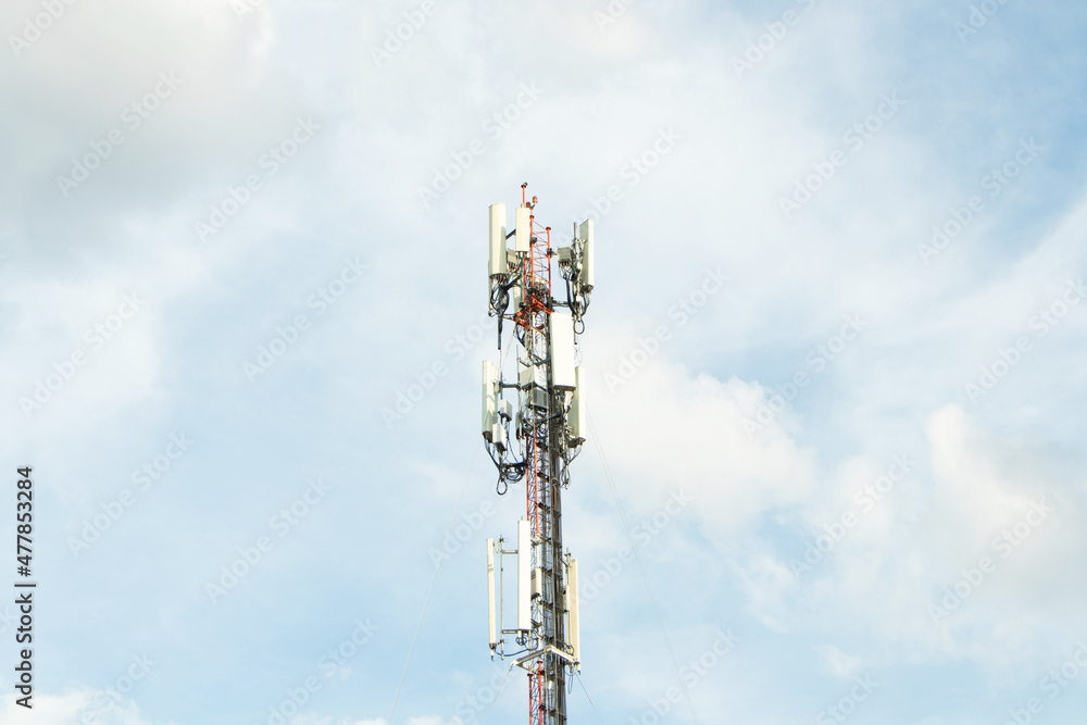 Communication tower telephone pole. Telecommunication tower of 4G and 5G cellular. Smart antennas mounted on a metal against with dense clouds sky background and bright sunlight in evening.