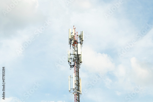Communication tower telephone pole. Telecommunication tower of 4G and 5G cellular. Smart antennas mounted on a metal against with dense clouds sky background and bright sunlight in evening.