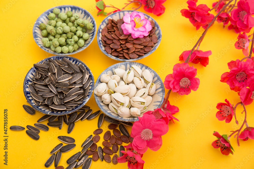 Tet Holiday, Lunar new year, chinese new year concept . Dried sunflower, lotus, watermelon and pumkin seeds top view isolated on yellow. Tet snacks Tet Holiday, Lunar new year, chinese new year concept . Dried sunflower, lotus, watermelon and pumkin seeds top view isolated on yellow. Tet snacks
