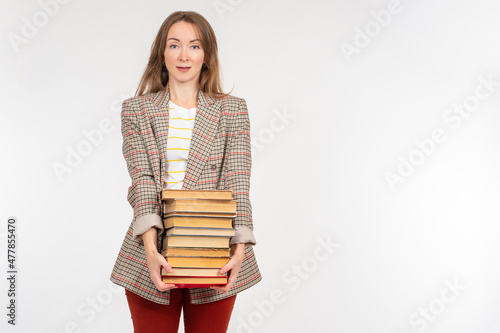 Woman with books on light background. Adult girl with textbooks. Portrait businesswoman with pile books. Female student in plaid jacket looks at camera. University girl students on white background