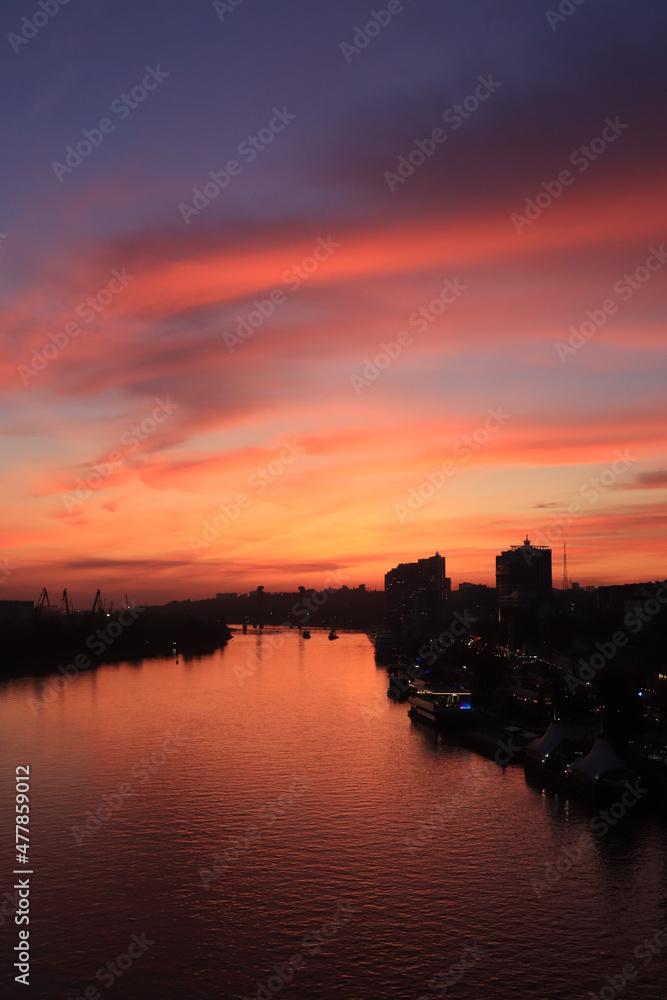 sunset on the river in the city, rays of the sun, golden hour, water and ships boats, evening landscape