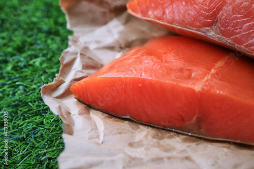 Red fish on the table, a slice of fish, seafood and alcohol, green lawn, salted fish