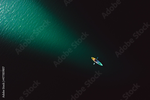 A guy enjoys the fresh and bright morning light while rowing a kayak.
