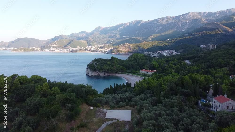 Coastal area with mountains and dense forests - aerial view. Famous resorts located at the foot of the mountain. Drone Shot of King's Beach (Milocer Beach) in Montenegro.