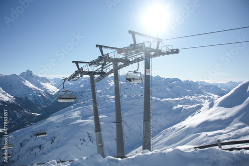 chair lift in front of mountain panorama in winter