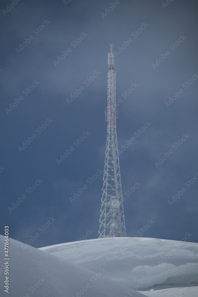 telecommunication tower covered in ice on a snowy mountain