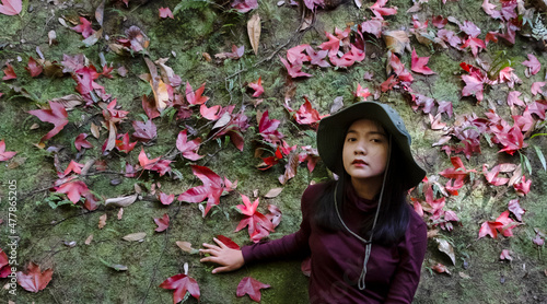 Tourist girl and beautiful maple leaf on the big stone at Thamyai waterfall, Phugradung National park Thailand. photo