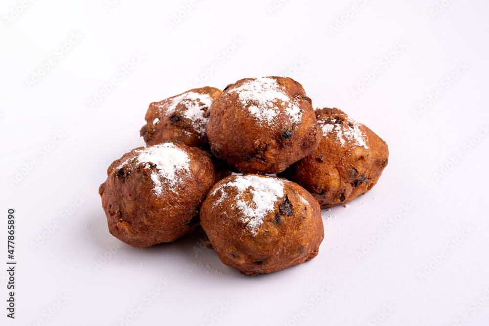 A pile of Dutch traditional oliebollen (dough balls) with powdered sugar isolated on white background A pile of Dutch traditional oliebollen (dough balls) with powdered sugar isolated on white background