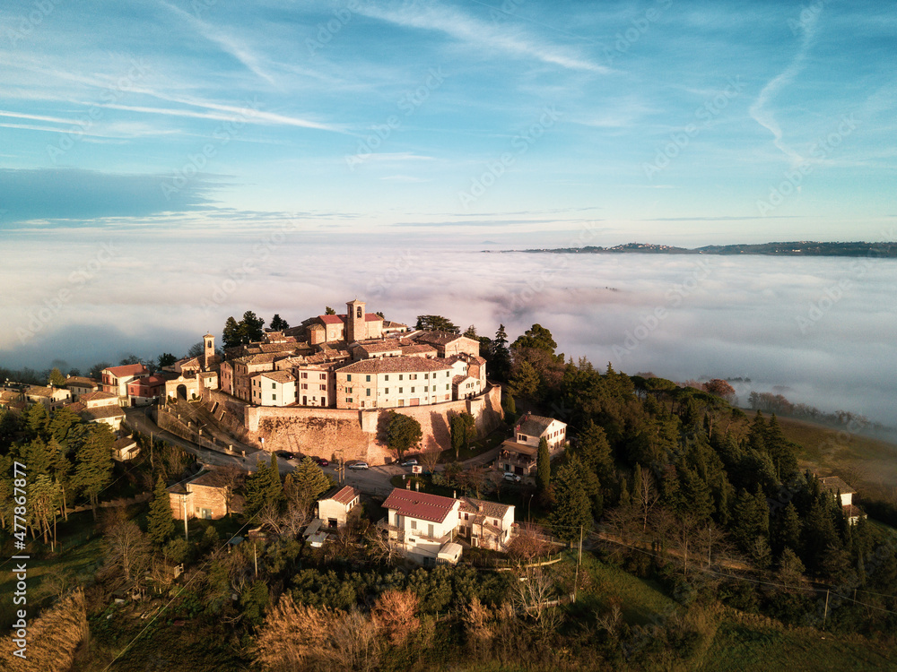 aerial view of the medieval village of Piticchio di Arcevia in the province of Ancona in the Marche region of Italy immersed in the fog