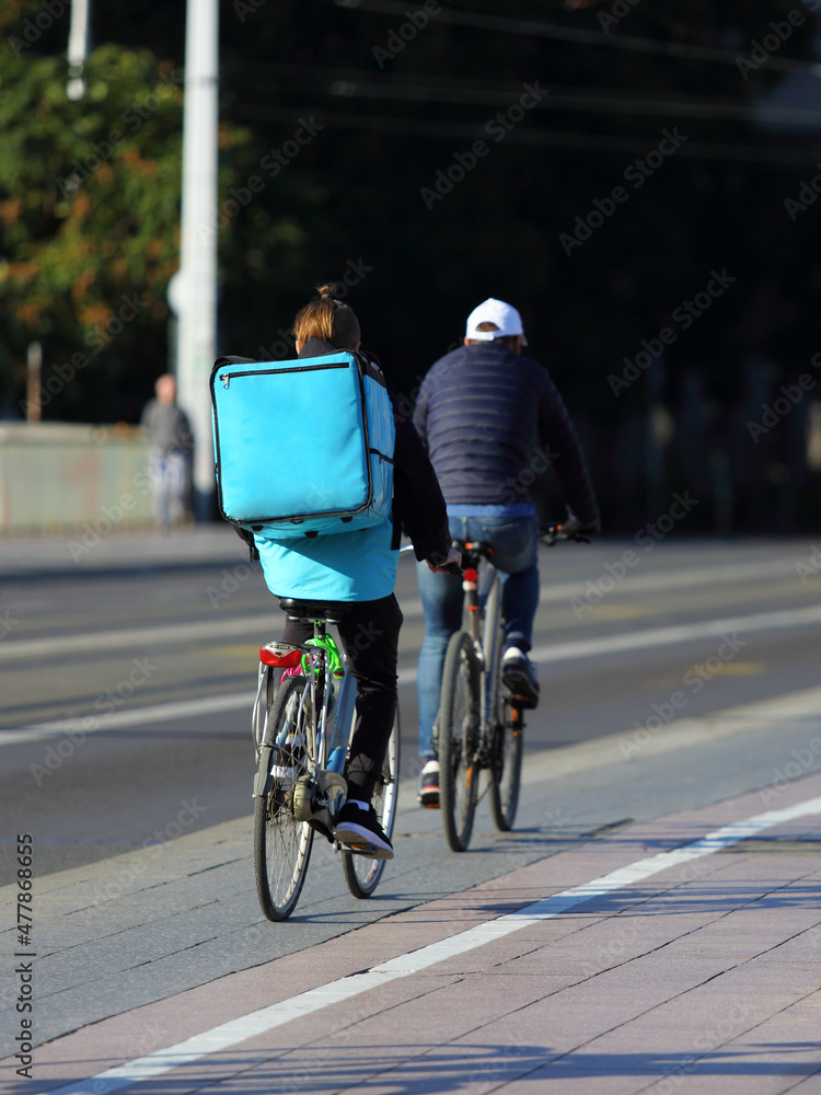 Kurier na rowerze, dostarcza jedzenie na ulicach miasta.	 - obrazy, fototapety, plakaty 