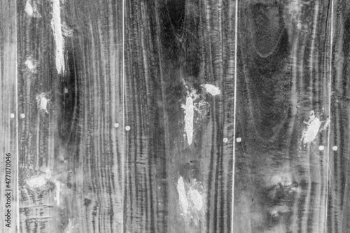 Black and white image of an old wooden board with white repair spots for texture background