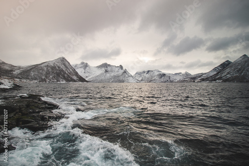 View from the isolated village of Husoy on the island of Senja  Norway. A very lonely fishing village. A view of the stormy Norwegian sea and snow-capped hills beyond the North Pole