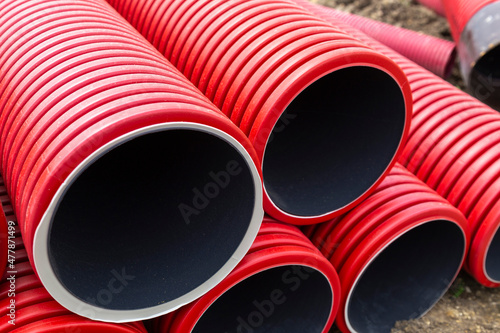 Gros plan sur plusieurs tubes gainés rouges pour réseaux électriques sur un chantier de construction © Olivier SALESSE