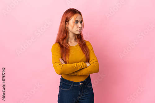 Teenager Russian girl isolated on pink background keeping the arms crossed