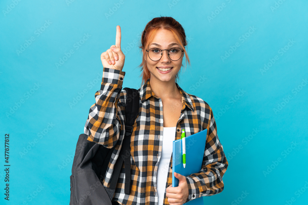 Teenager student Russian girl isolated on blue background pointing up a great idea Teenager student Russian girl isolated on blue background pointing up a great idea