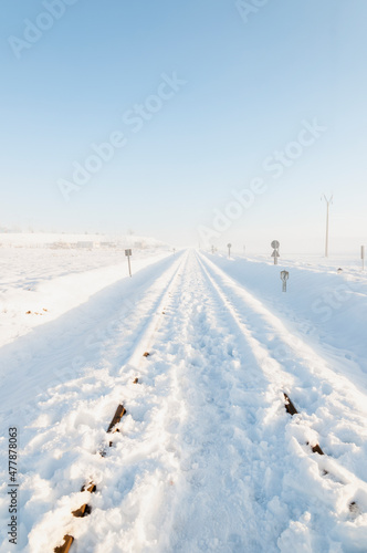 Railway tracks almost covered with snow, after a snowfall, on a sunny morning, © aguscrespophoto