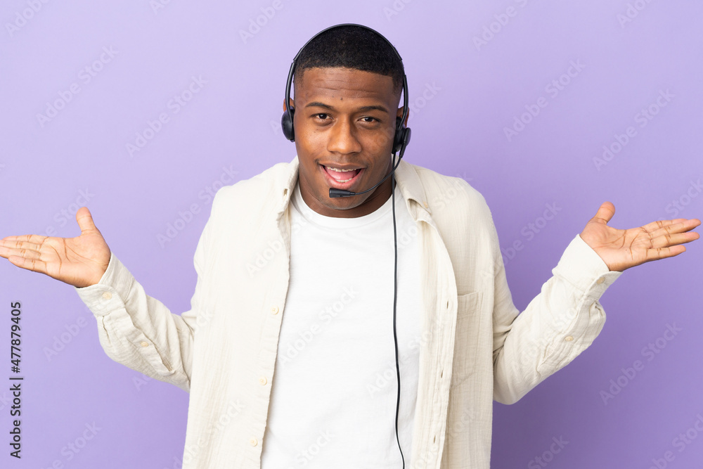 Naklejka premium Telemarketer latin man working with a headset isolated on purple background with shocked facial expression